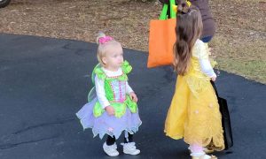 Two children dressed in costumes at trunk or treat