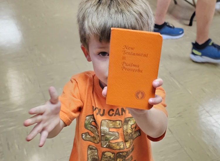 New Testament Held by Child